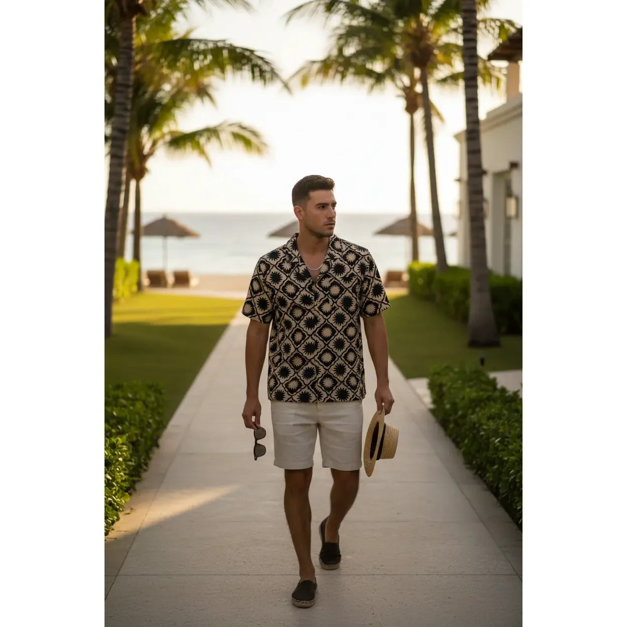 Man on a beach wearing Kuwalla Linen Yacht Shirt in navy with brown tropical print and Cuban collar.