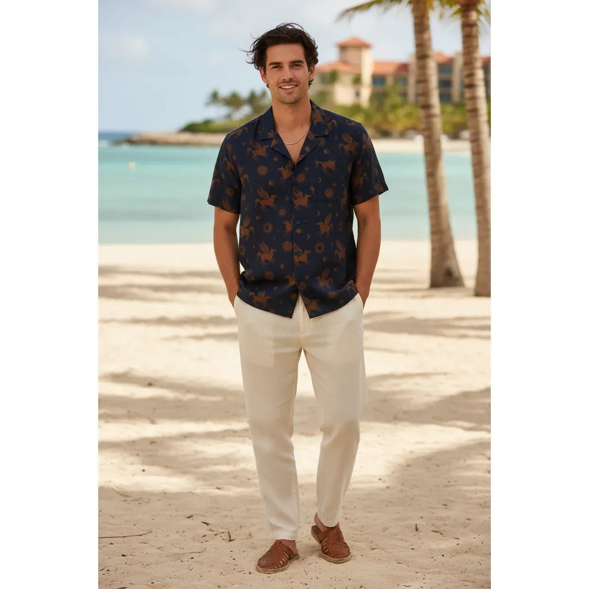 Man on a beach wearing Kuwalla Linen Yacht Shirt in navy with brown tropical print and Cuban collar.