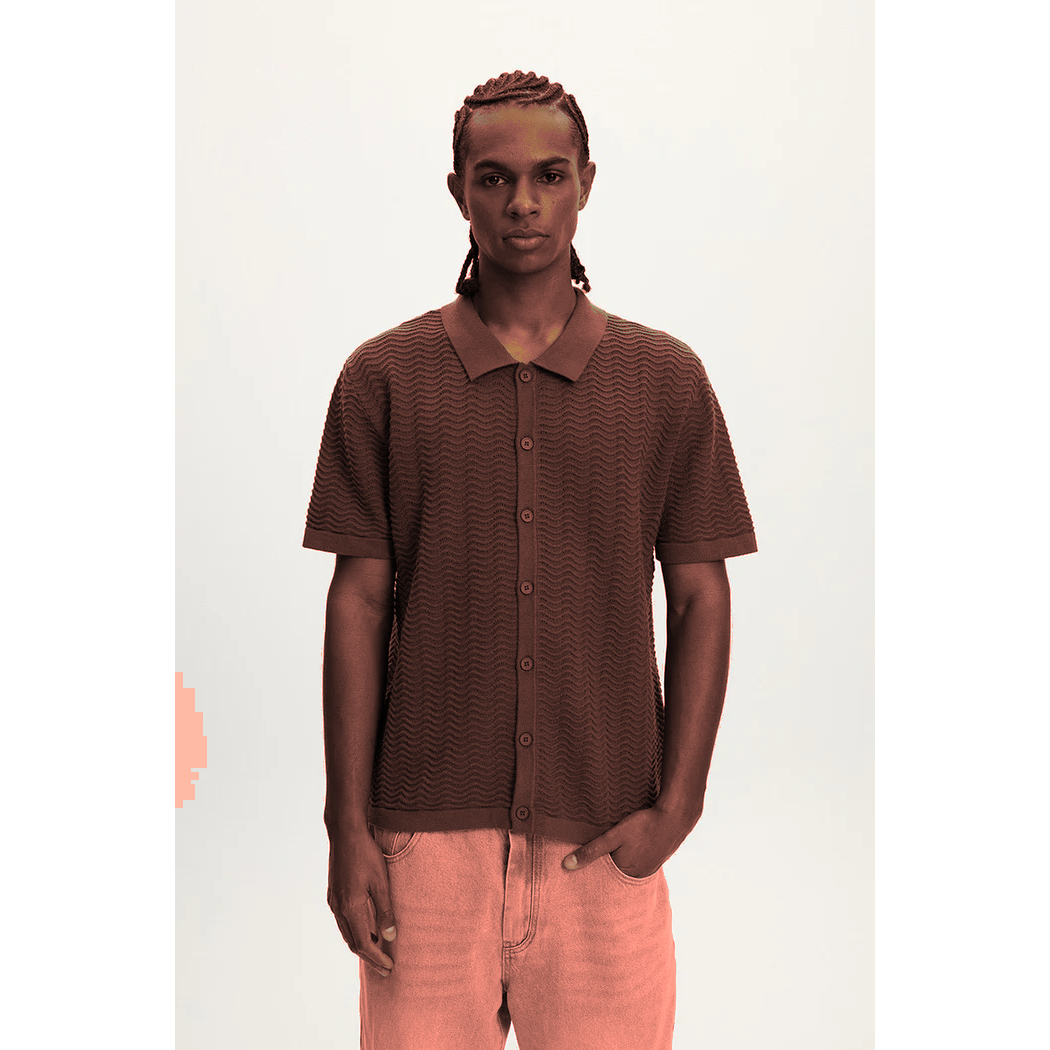 Male model wearing Kuwalla Wave Knit Polo in brown, 100% cotton textured knit, oversized relaxed fit.