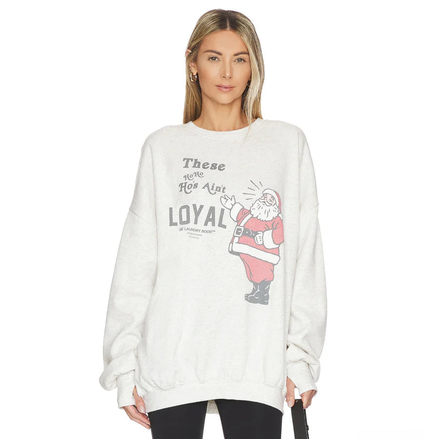 Model wearing cream oversized sweater with Santa graphic and LOYAL slogan from Laundry Room Ain&#39;t Crew.