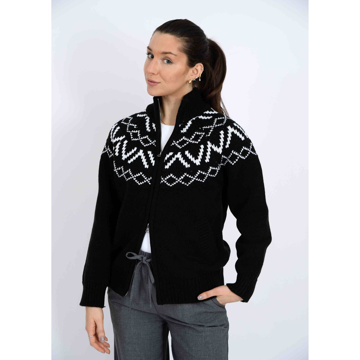 Model wearing Leocadia Mock Neck Zip Cardigan in black with white Nordic yoke, full-zip knit.
