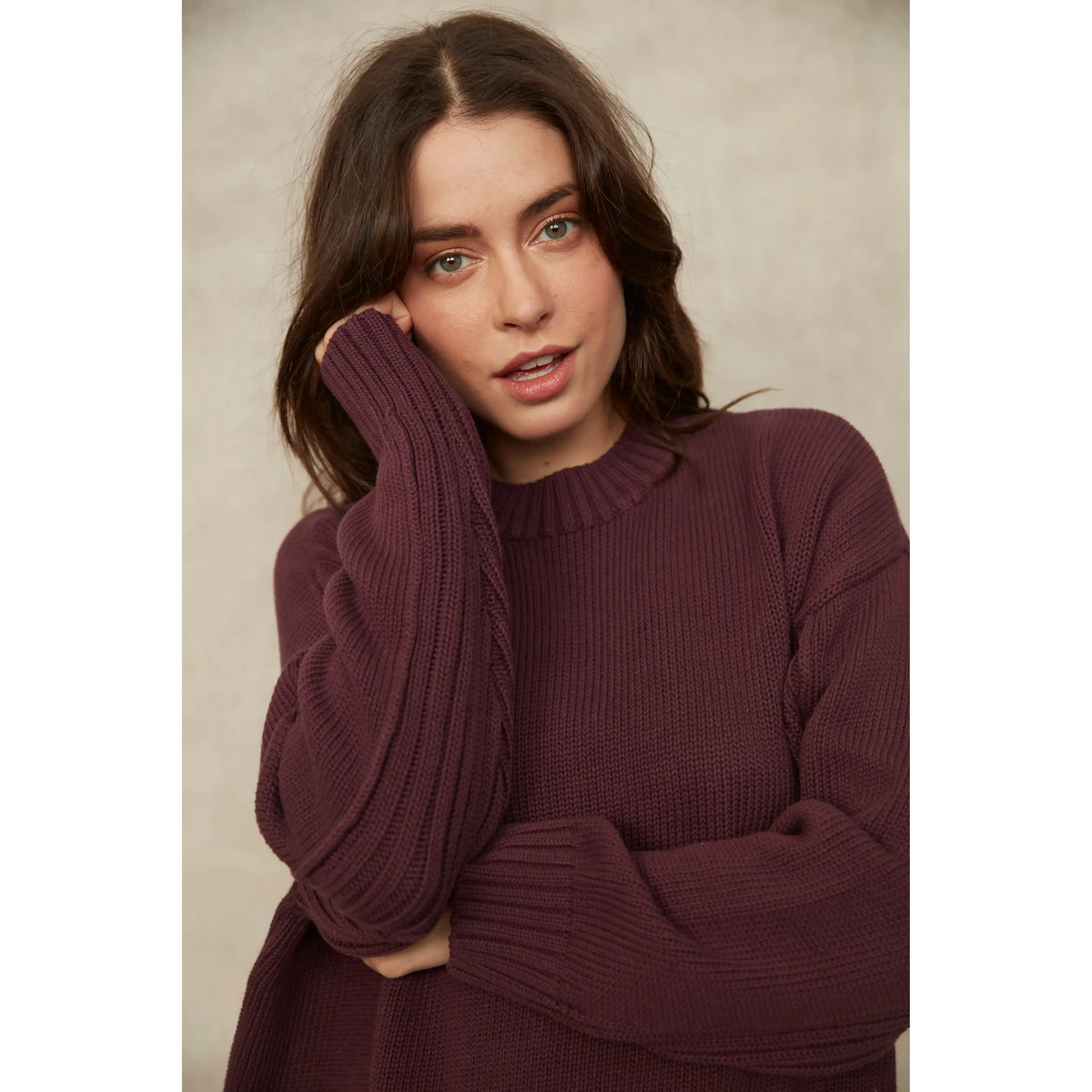Woman wearing a deep burgundy long sleeve crew neck knit sweater with ribbed cuffs and hem for a cozy, flattering fit.