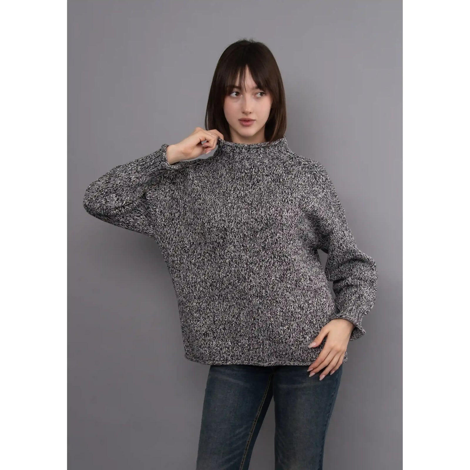 Model wearing a black twist funnel neck sweater with a multi-tonal textured knit pattern and stand-up collar.