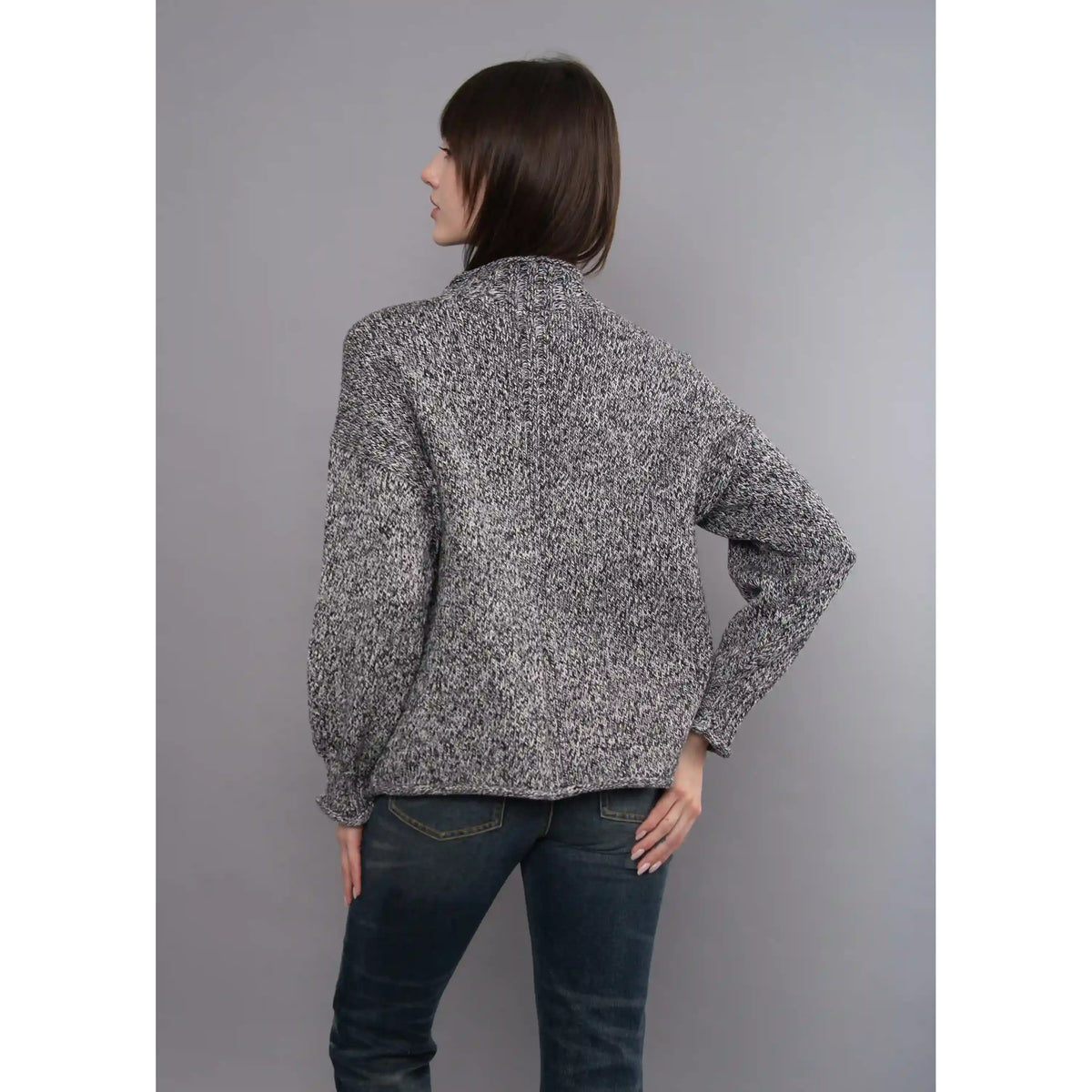 Back view of the Lucretia funnel neck sweater featuring a multi-tonal twist knit pattern and stand-up collar.