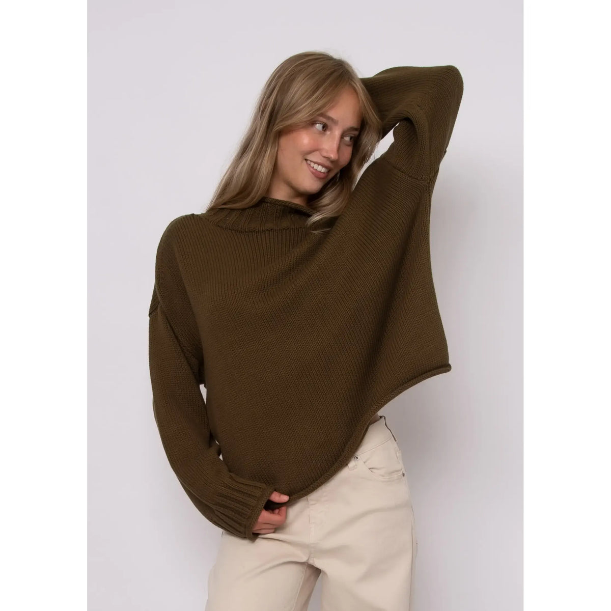 Woman wearing an olive green Lucretia funnel neck sweater with a ribbed texture and relaxed fit.