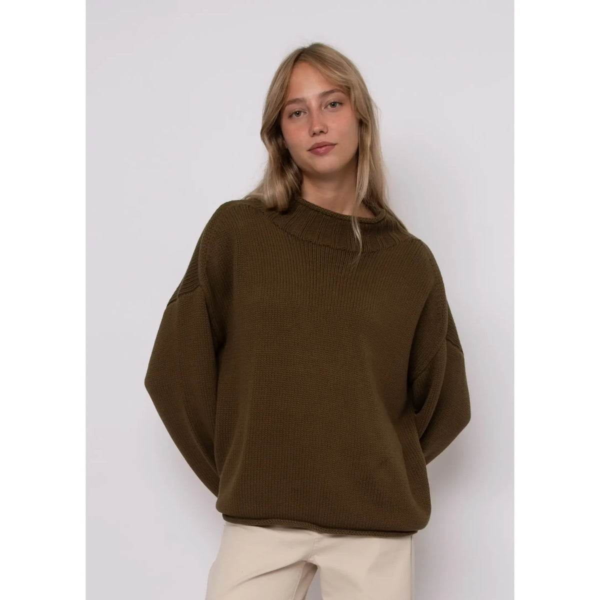 Model wearing an olive green Lucretia funnel neck sweater with a ribbed stand-up collar and relaxed fit.