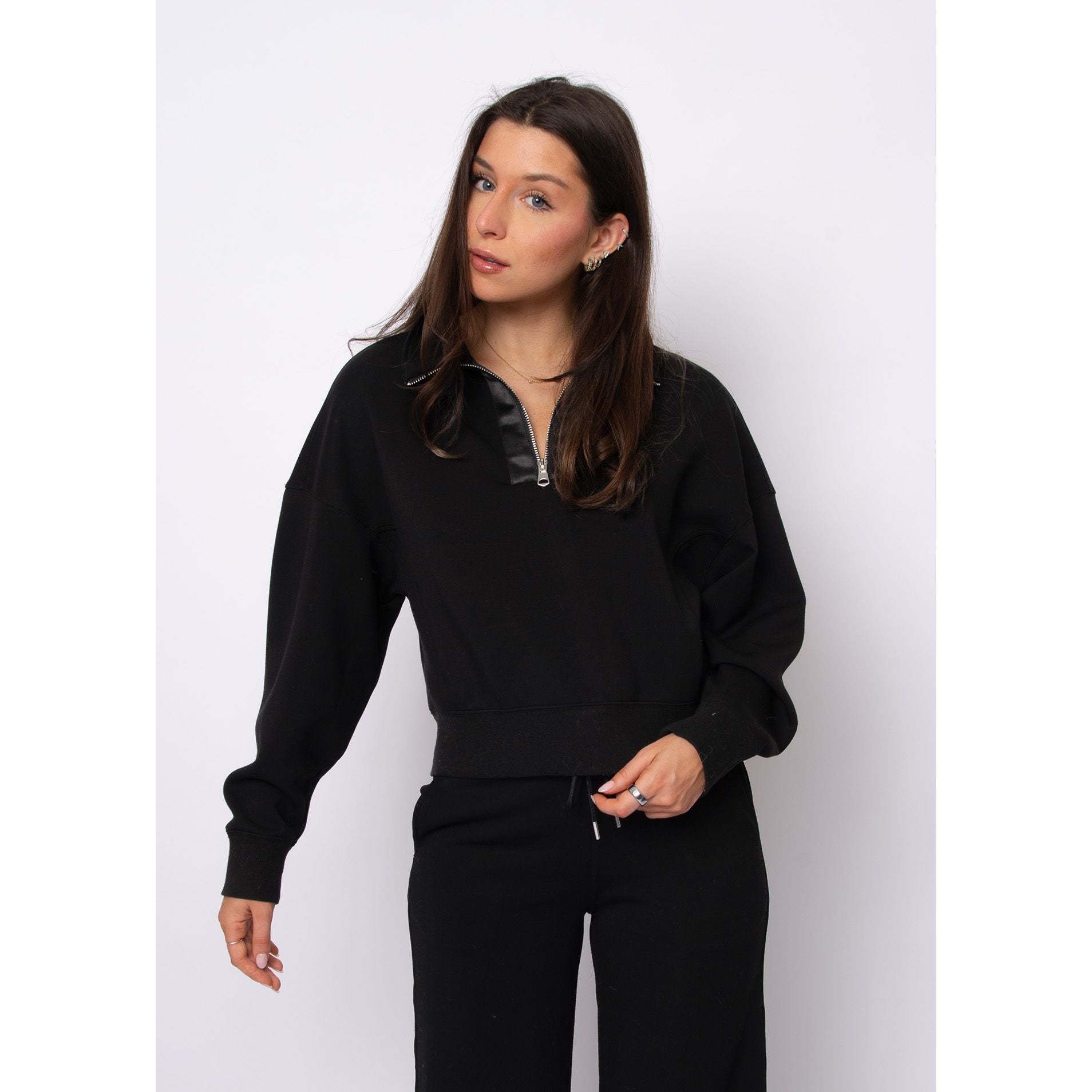 Model wearing black Mailyn soft-knit half-zip pullover with satin trim, cropped silhouette, and relaxed fit.
