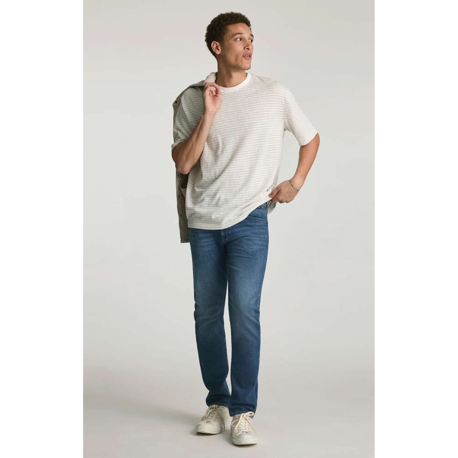 Mavi Jake Mid Explorer Denim jeans on male model; medium blue, regular rise, slim through hip and thigh.