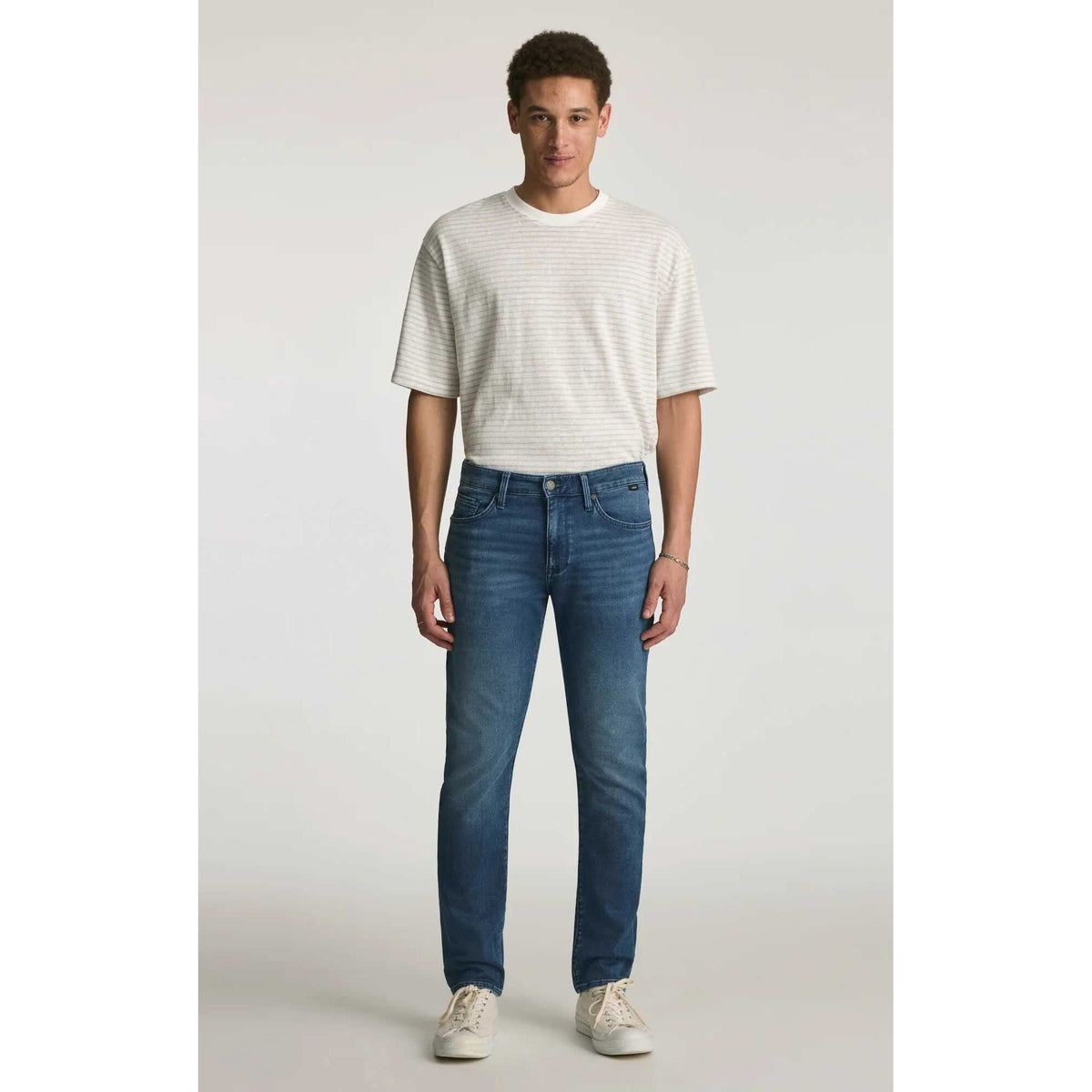 Mavi Jake Mid Explorer Denim jeans on male model; medium blue, regular rise, slim through hip and thigh.