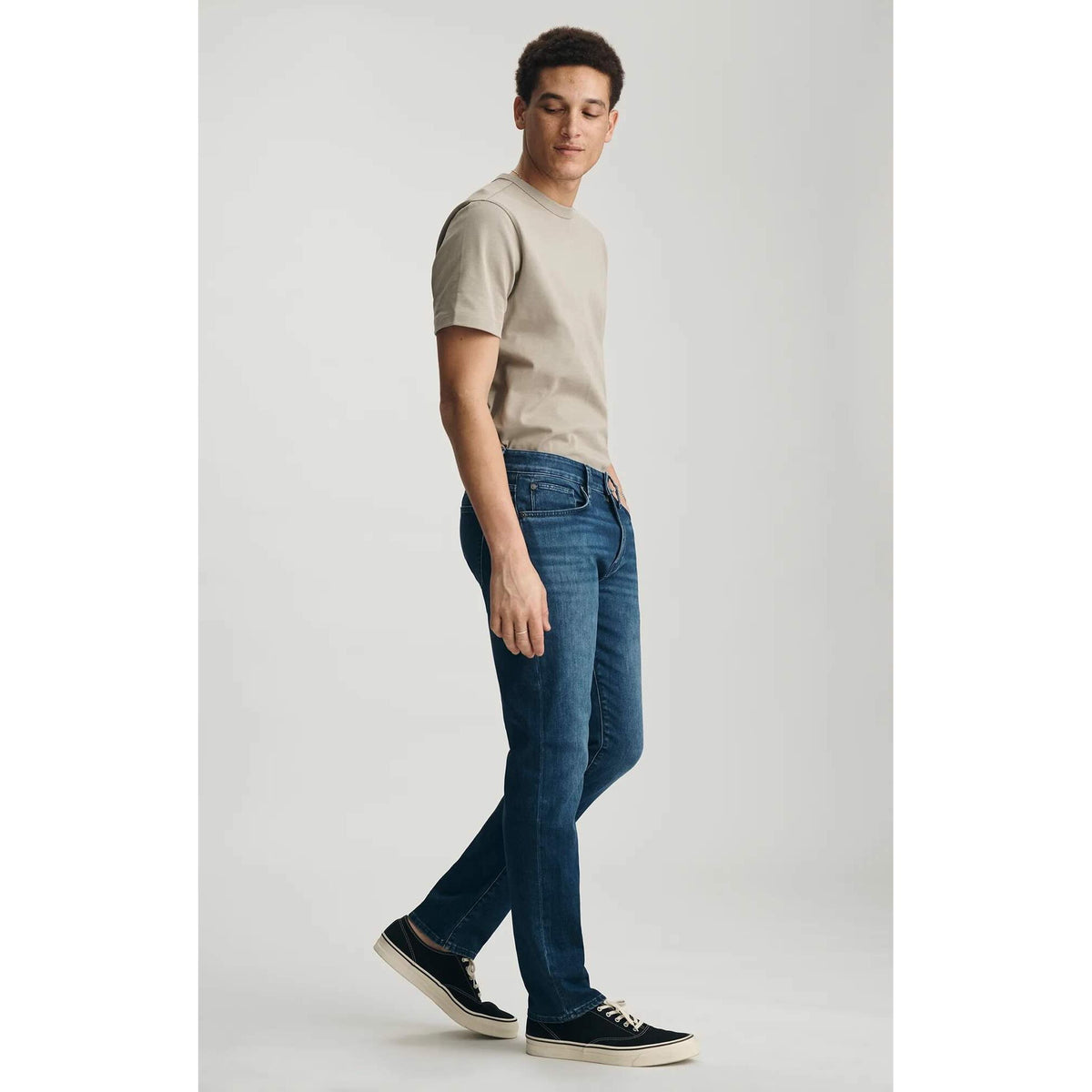 Model wearing Mavi Marcus Dark Air-Lite Denim jeans in dark wash with beige tee and black sneakers.