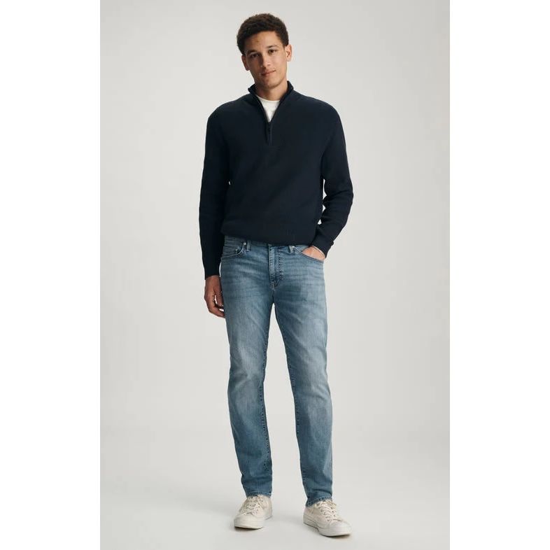 Mavi Marcus Mid Brushed Organic Vintage Denim jeans on a model, paired with a navy pullover and white sneakers.