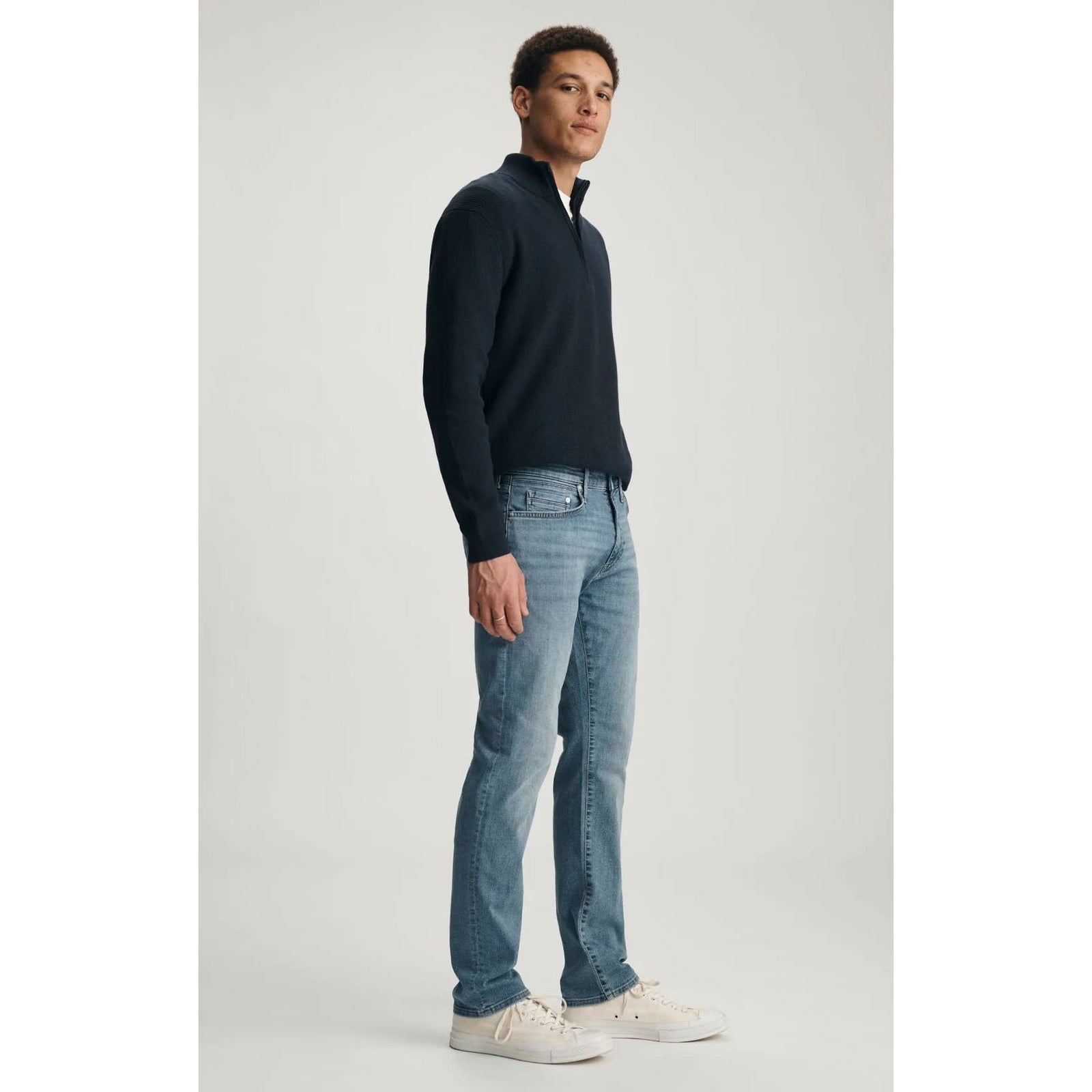 Mavi Marcus Mid Brushed Organic Vintage Denim jeans on a model, paired with a navy pullover and white sneakers.
