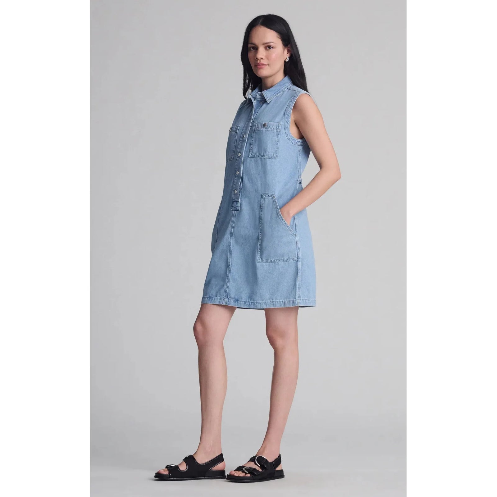 Woman wearing a sleeveless denim Mavi Simla Pocket Dress with snap buttons and utility pockets from Mavi.