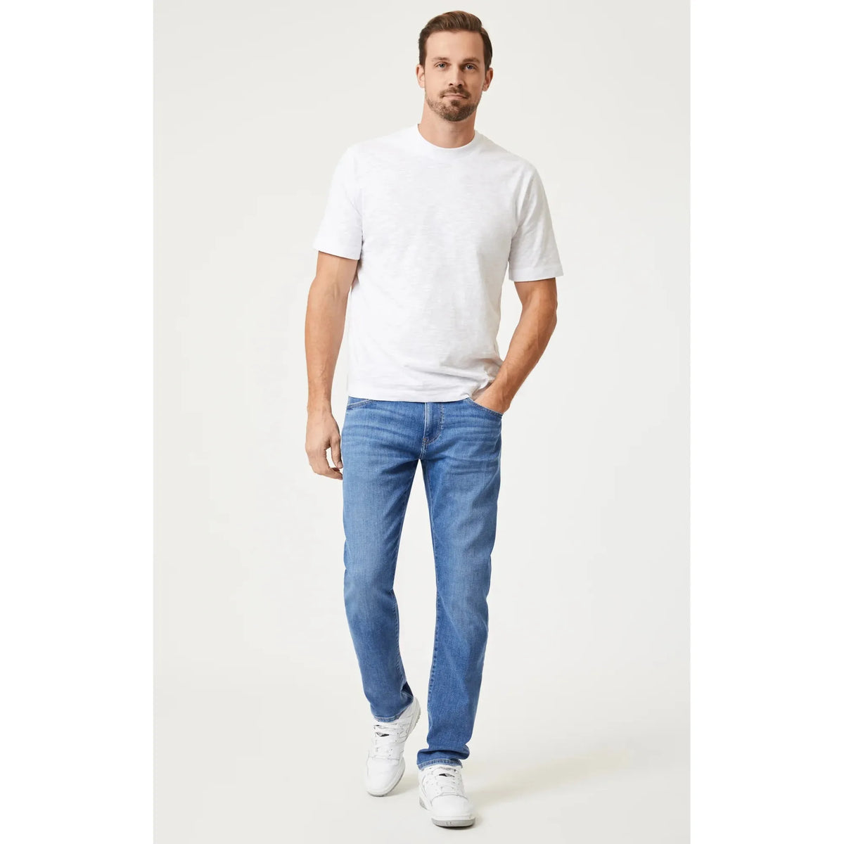 Stylish man wearing a Mavi Slub Short Sleeve T-Shirt and blue jeans, showcasing a timeless casual look.