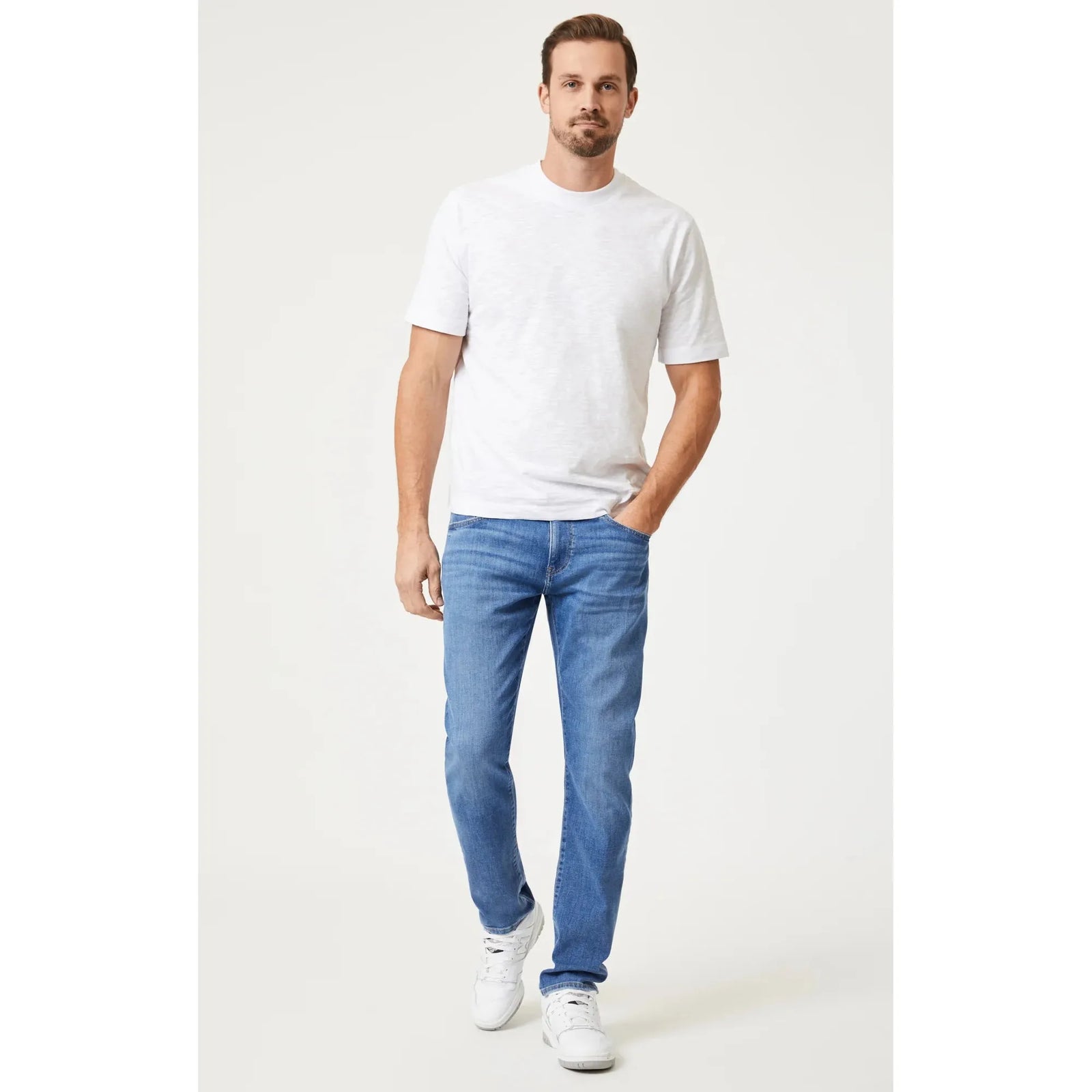 Stylish man wearing a Mavi Slub Short Sleeve T-Shirt and blue jeans, showcasing a timeless casual look.