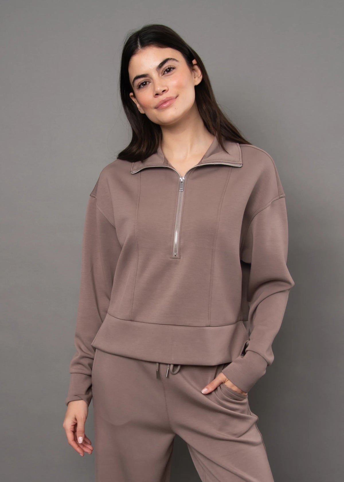 Soft knit quarter-zip top in muted mauve with silver zipper, offering a comfortable casual utility look.