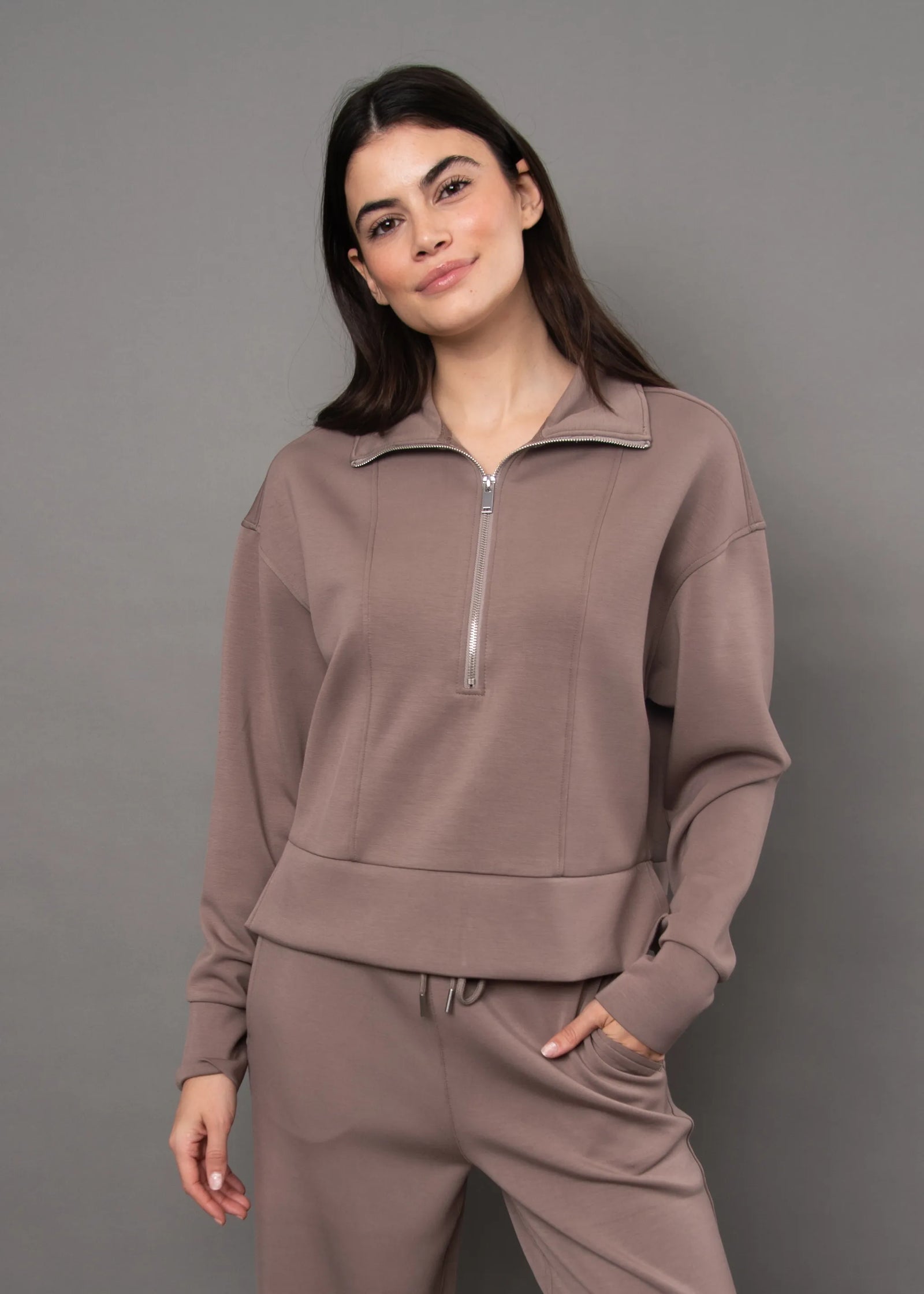 Soft knit quarter-zip top in muted mauve with silver zipper, offering a comfortable casual utility look.