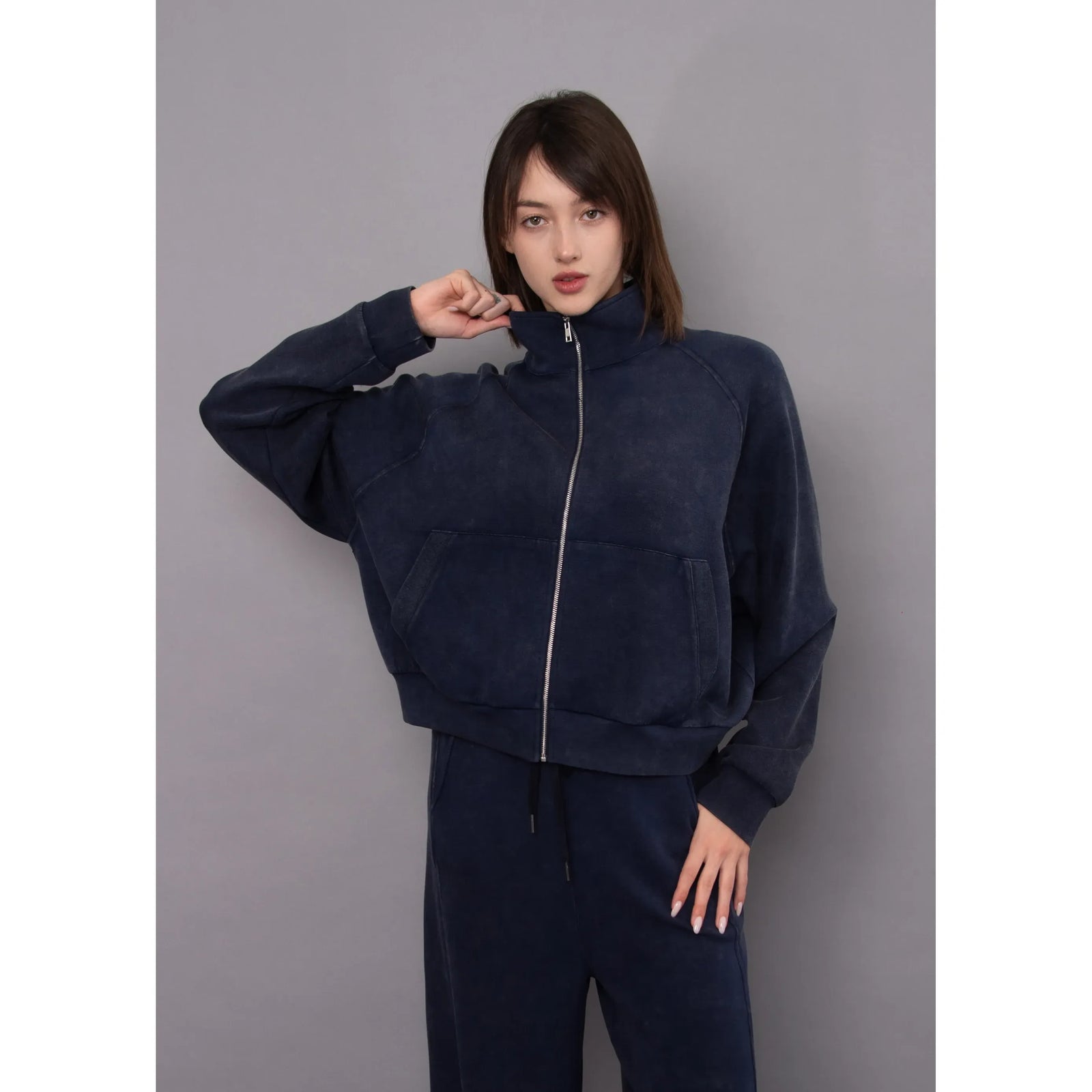 Ophelie Soft Knit Zip Up Top in mineral washed navy featuring a high collar, front kangaroo pocket, and relaxed fit.