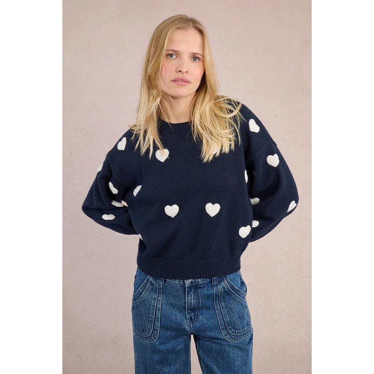 Woman wearing Molly Bracken Knitted Heart Crew Sweater in navy with white hearts and balloon sleeves.