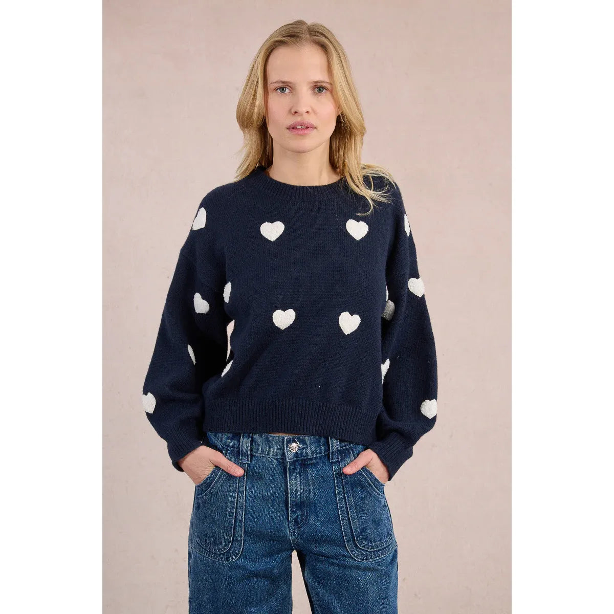 Woman wearing Molly Bracken Knitted Heart Crew Sweater in navy with white hearts and balloon sleeves.