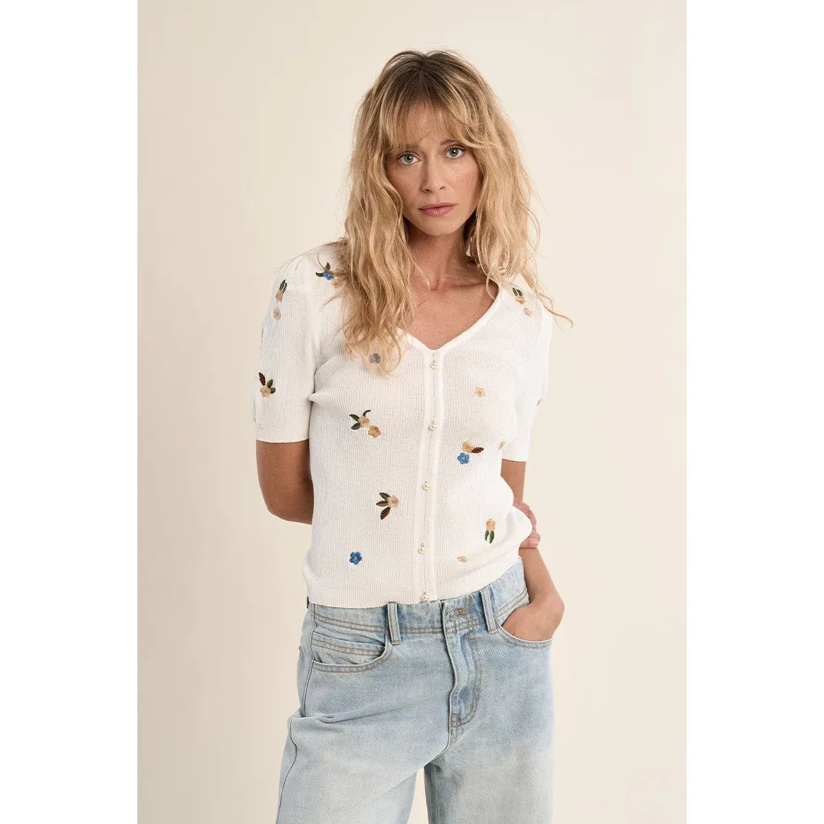 Molly Bracken Embroidered white short-sleeve sweater with floral embroidery, V-neck, button-front on a model.