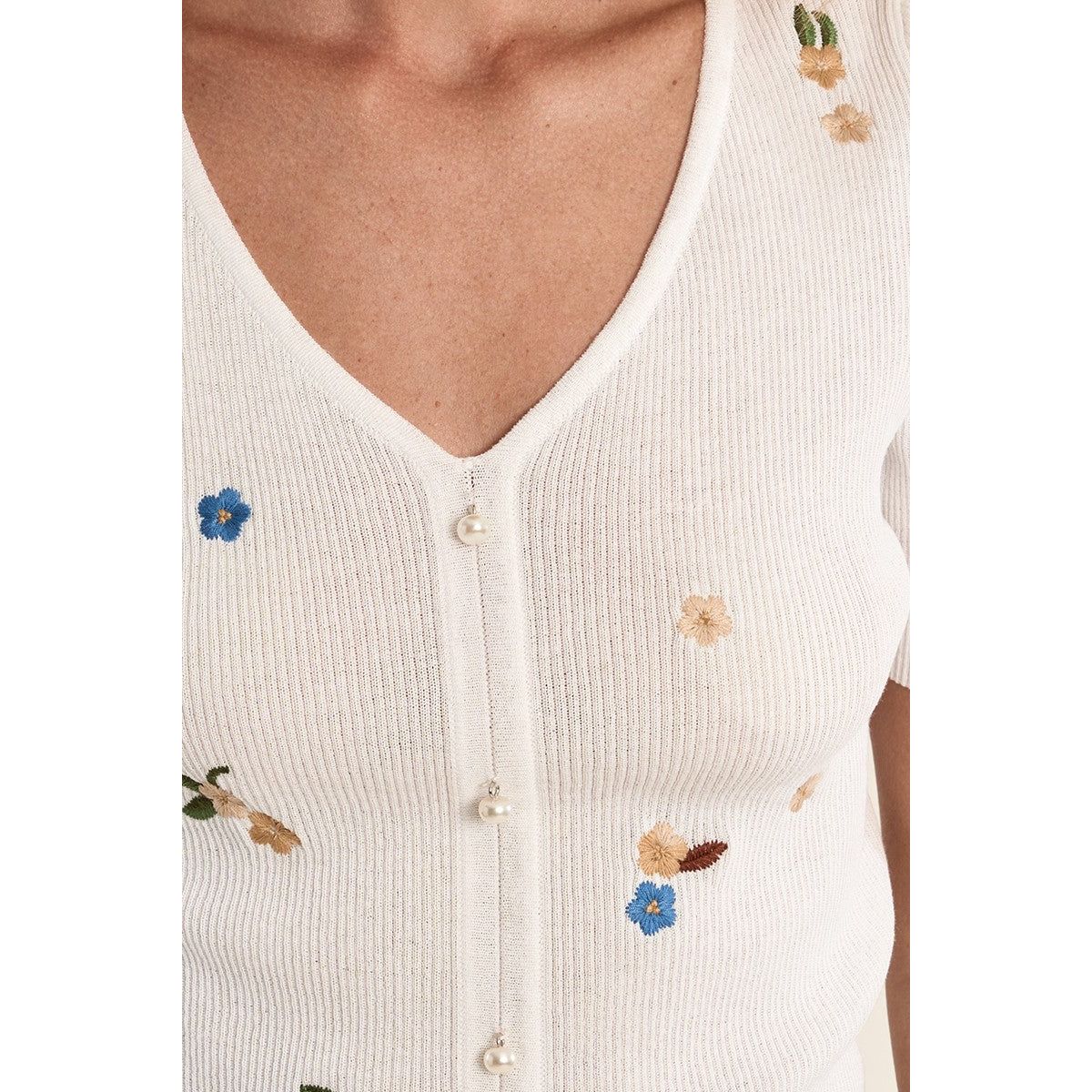 Molly Bracken white knit short-sleeve sweater with colorful floral embroidery and pearl-button front.