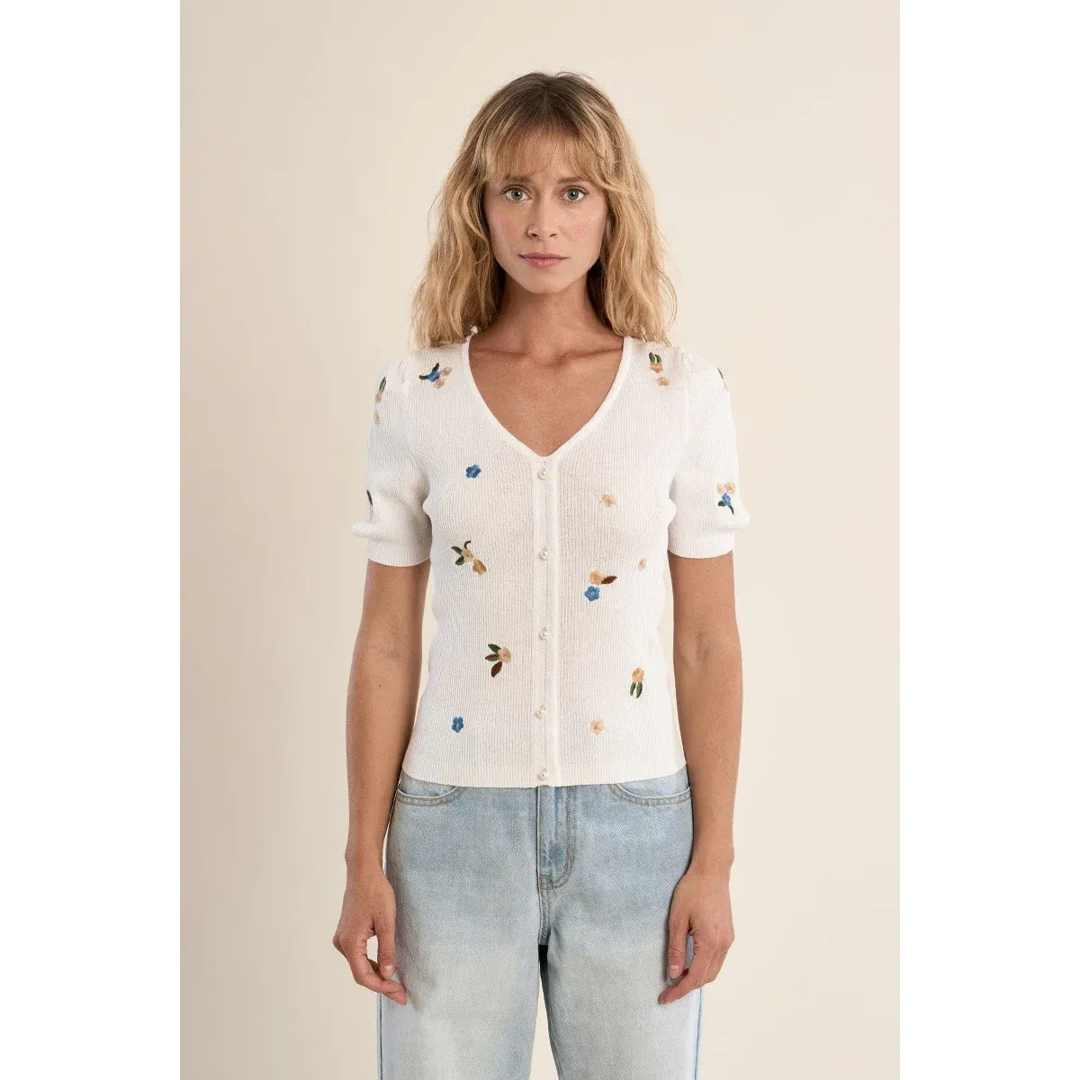 Molly Bracken white embroidered short-sleeve sweater with V-neck, button front, floral motifs on a model.