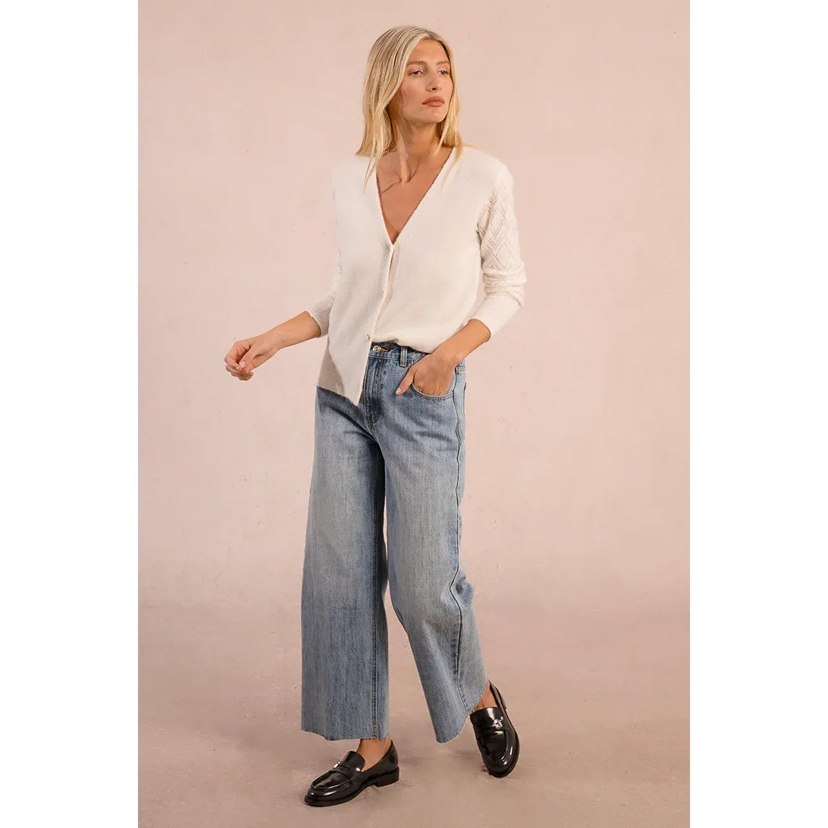 Molly Bracken Heart Button Cardigan in white knit with a wide V-neck and long openwork sleeves, paired with jeans.