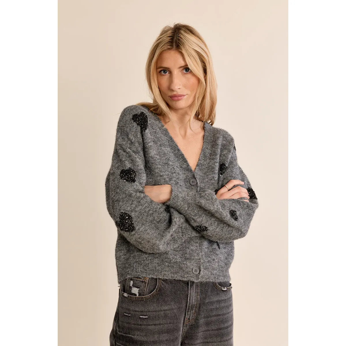 Grey knit cardigan with contrasting black beaded heart pattern, V-neck, and balloon sleeves.