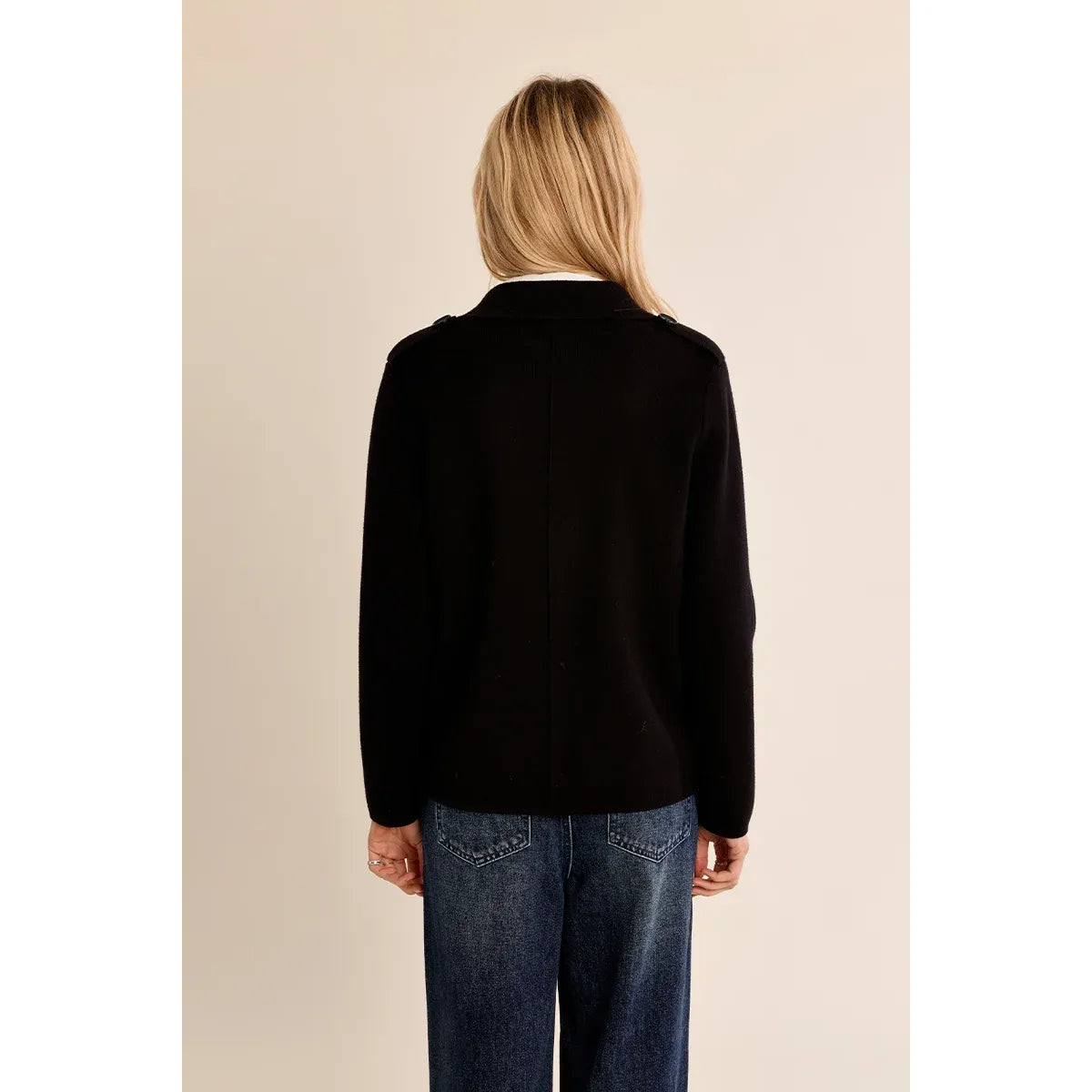 Back view of black Molly Bracken knit jacket with cropped silhouette, classic tailoring, and epaulet shoulders styling wide-leg jeans.