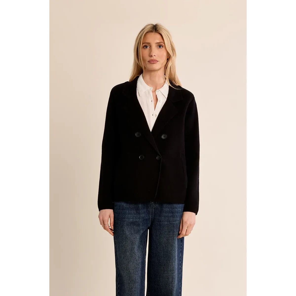 Black Molly Bracken knit blazer coat with cropped silhouette and double-breasted buttons, styled over a white shirt and blue jeans.