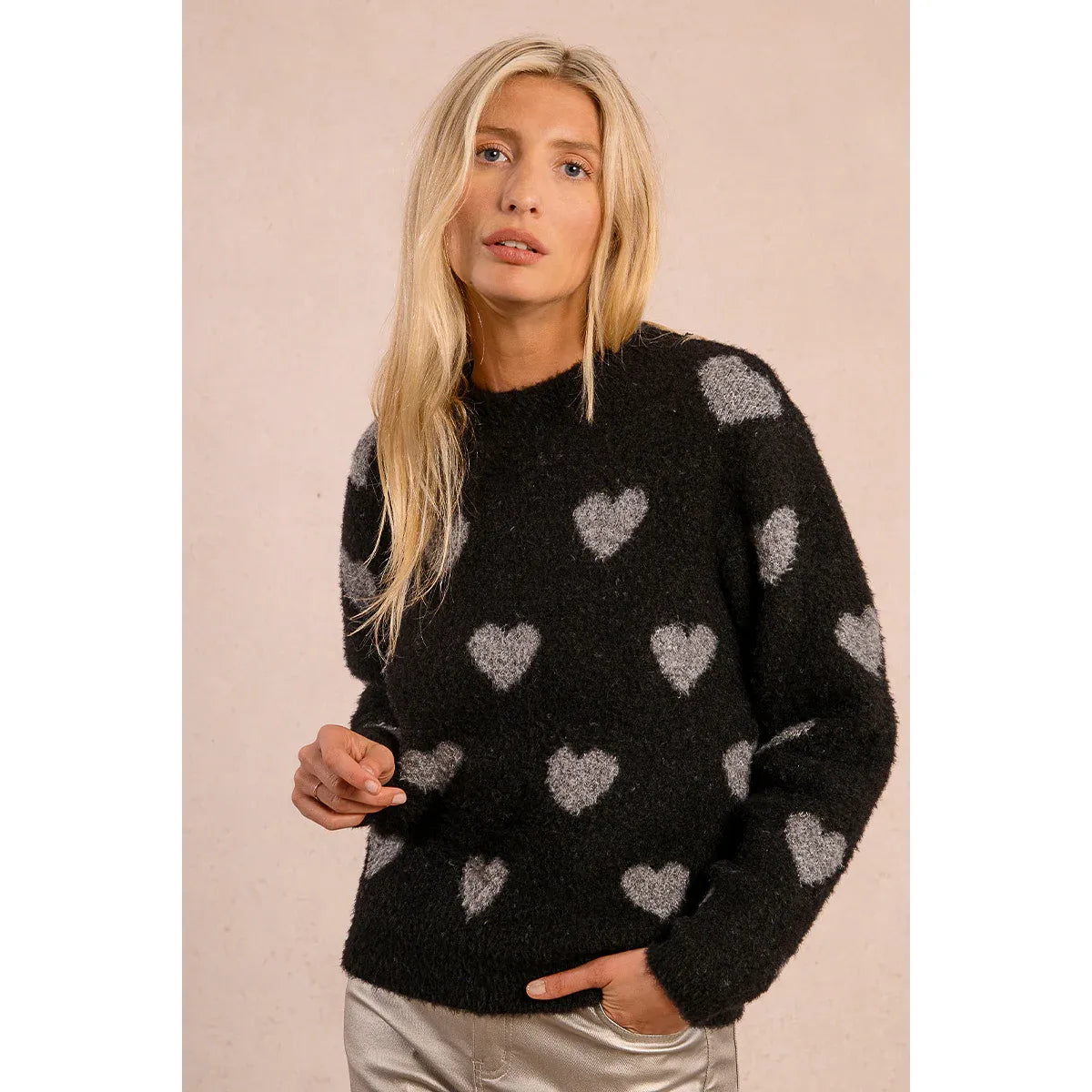 Molly Bracken Heart Sweater: beige fuzzy knit with white hearts, round neckline, worn with blue jeans.