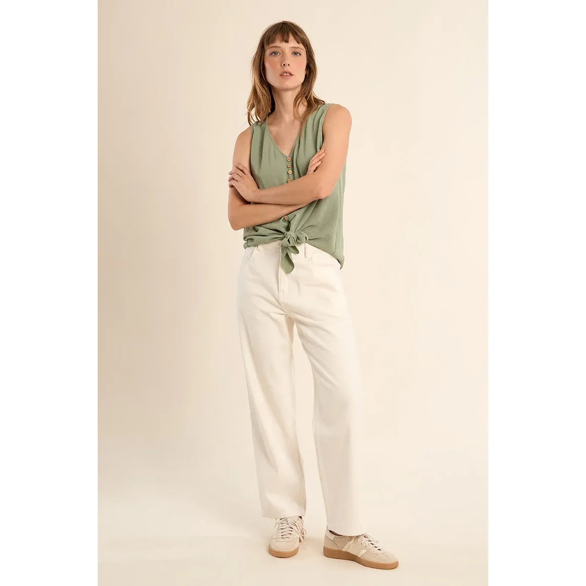 Molly Bracken Knotted Tank Top in sage green, V-neck with waist knot, modeled with white pants.