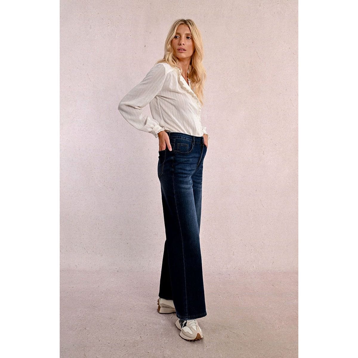 Model wearing Molly Bracken Jamie wide-leg denim pants in dark blue with light fading, front pockets, and zip fly.