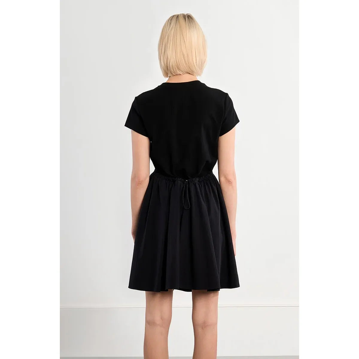 Black Molly Bracken nylon drawstring mini dress with boat neck and short sleeves on a model.