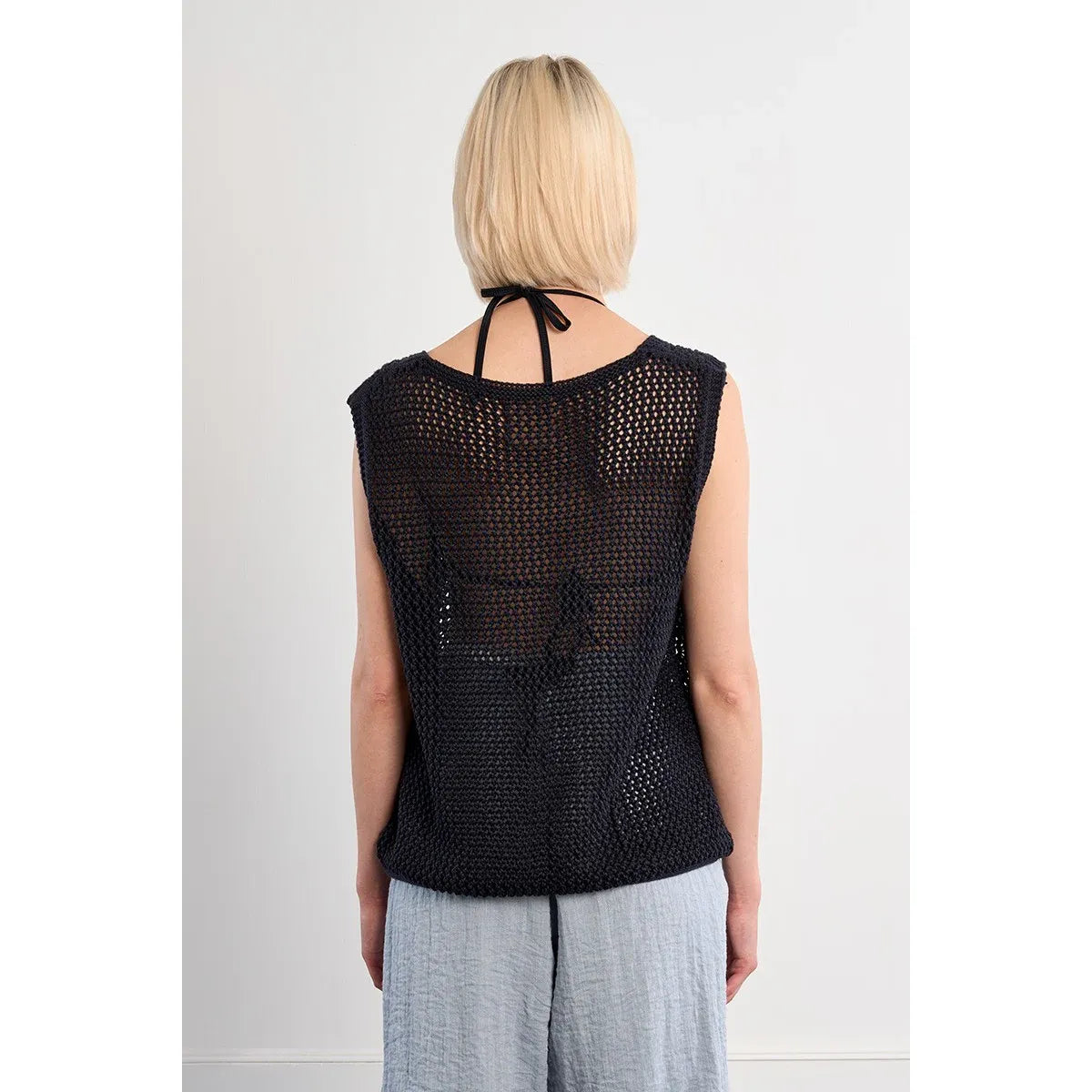 Molly Bracken Sleeveless Knit Top in black with openwork mesh and a halter neck tie (back view).