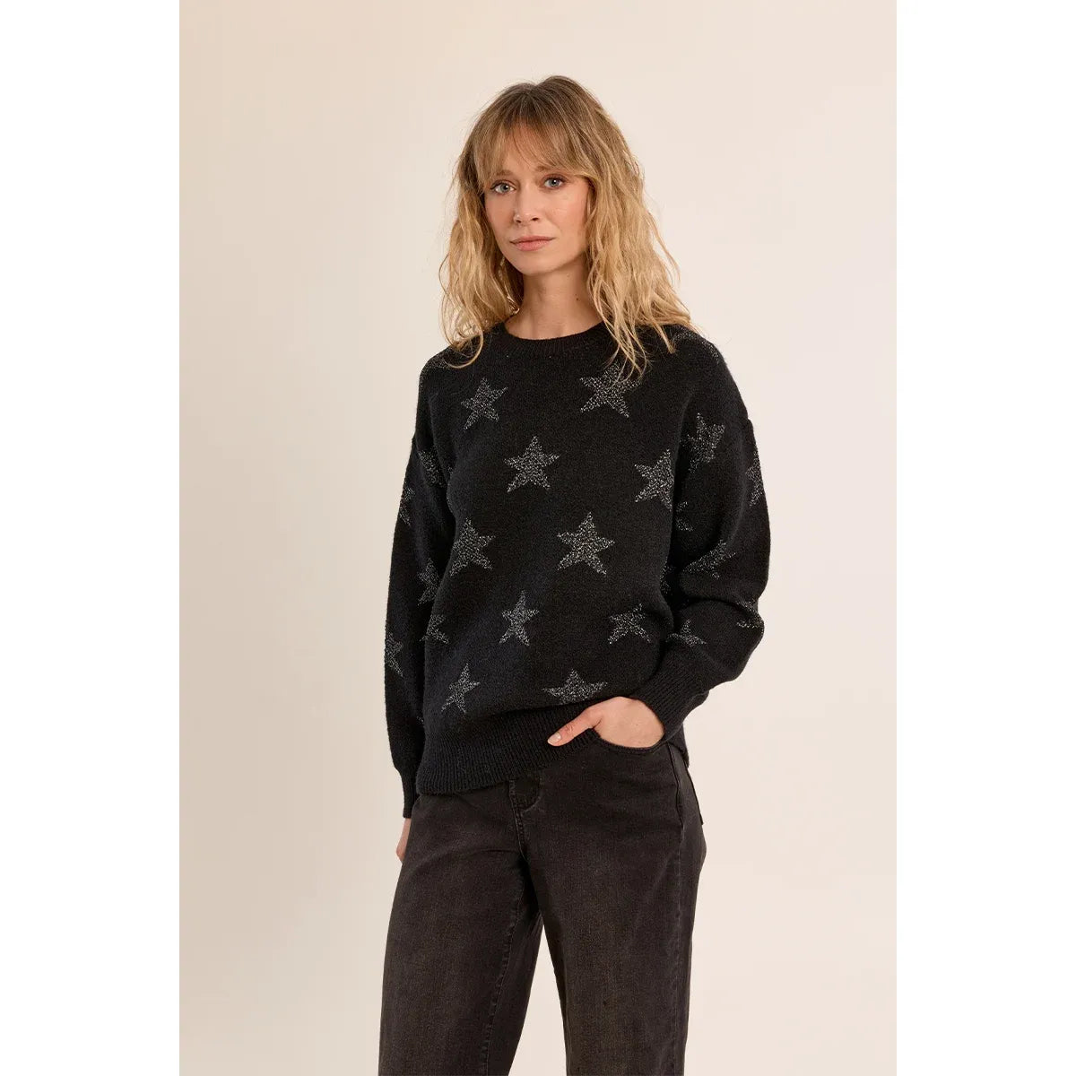 Black knit sweater featuring an iridescent glittery star pattern, long sleeves, round neckline, and relaxed straight fit ribbed trim.