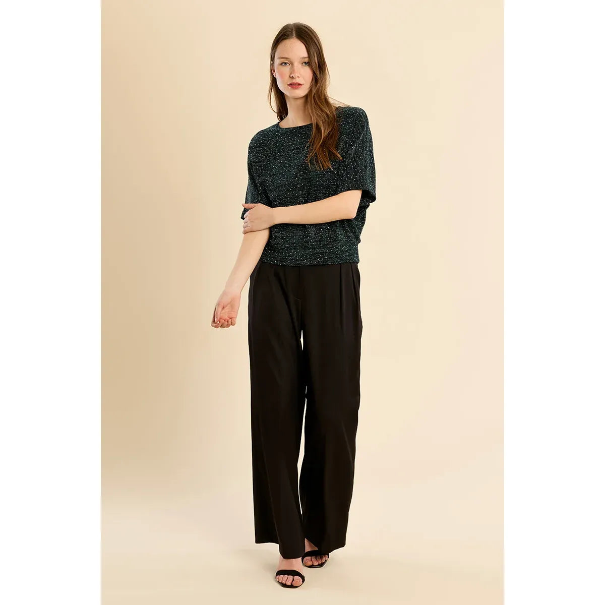 Sparkling dark rhinestone top with wide short sleeves and metallic shimmer, styled here with black wide-leg trousers for a festive夜 out look.