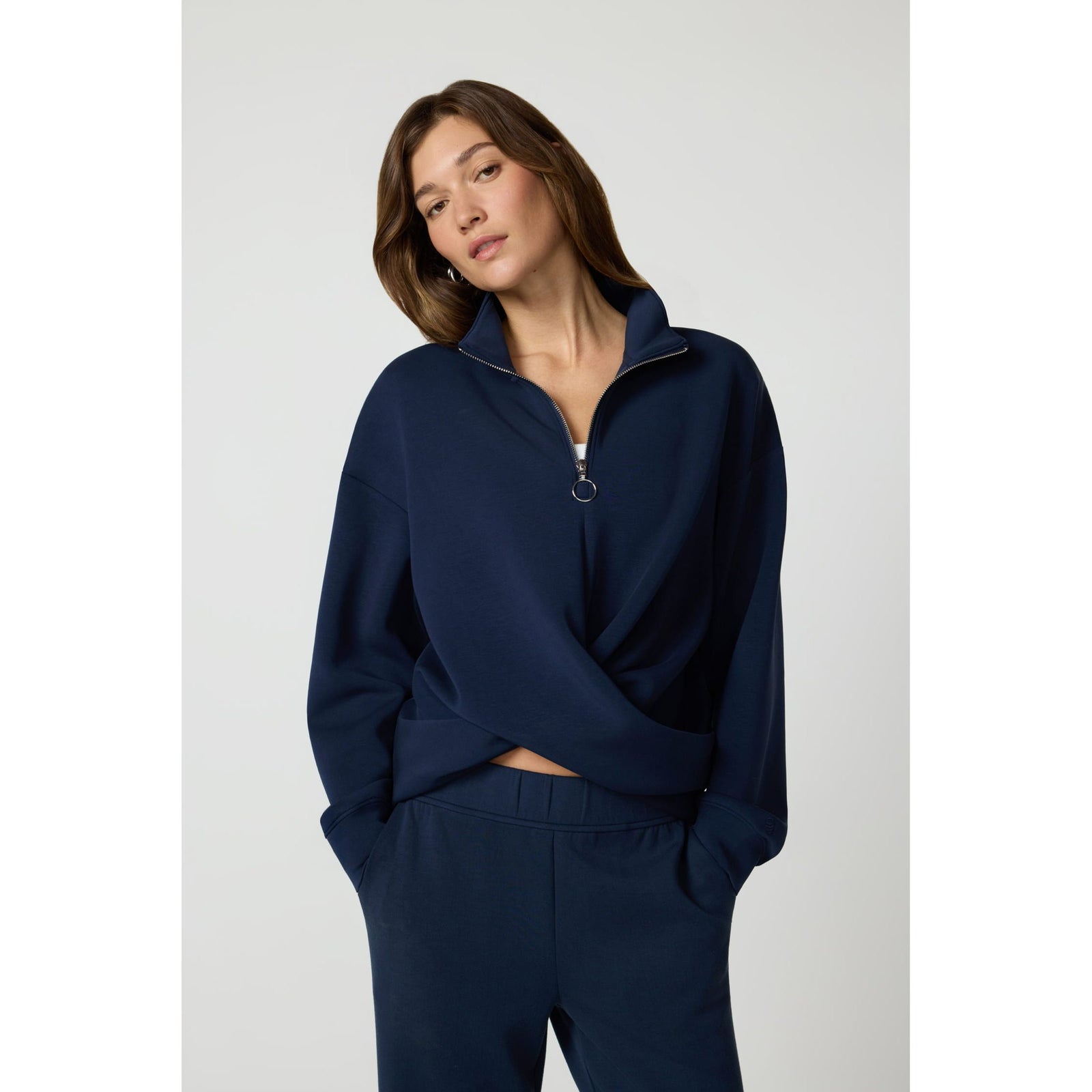 Navy blue quarter-zip pullover featuring a crossover front detail, dropped shoulders, and a ring zipper pull for modern activewear style.