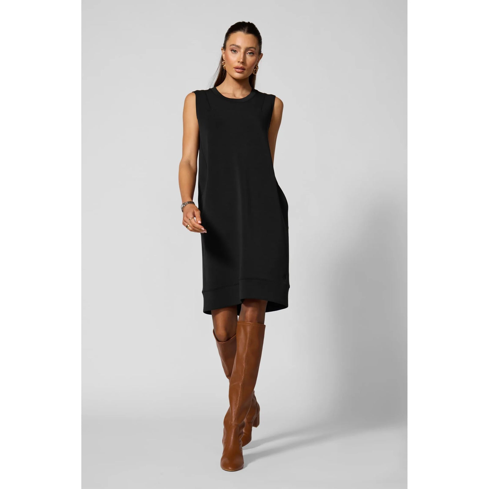 Black sleeveless dress with insert pockets and structured fit, blending casual luxury with modern tailored elements for everyday wearability.