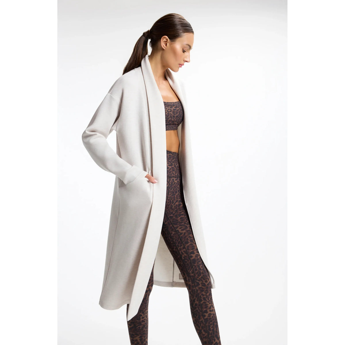 Light beige long cardigan with open front and pockets, styled over leopard print activewear for polished loungewear comfort.