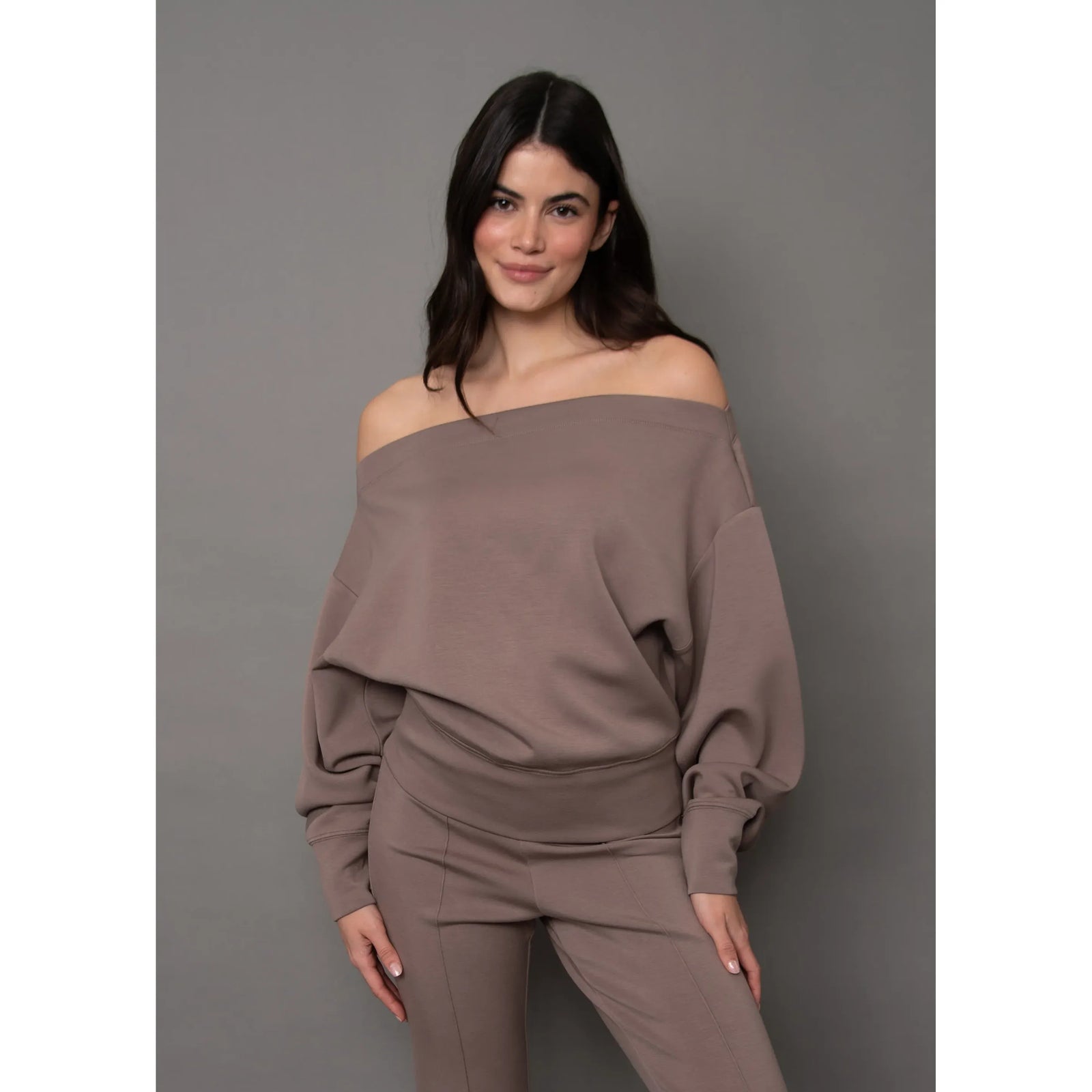 Soft taupe knit drop shoulder top styled off the shoulder, featuring relaxed sleeves and comfortable stretch fabric for effortless sophistication.