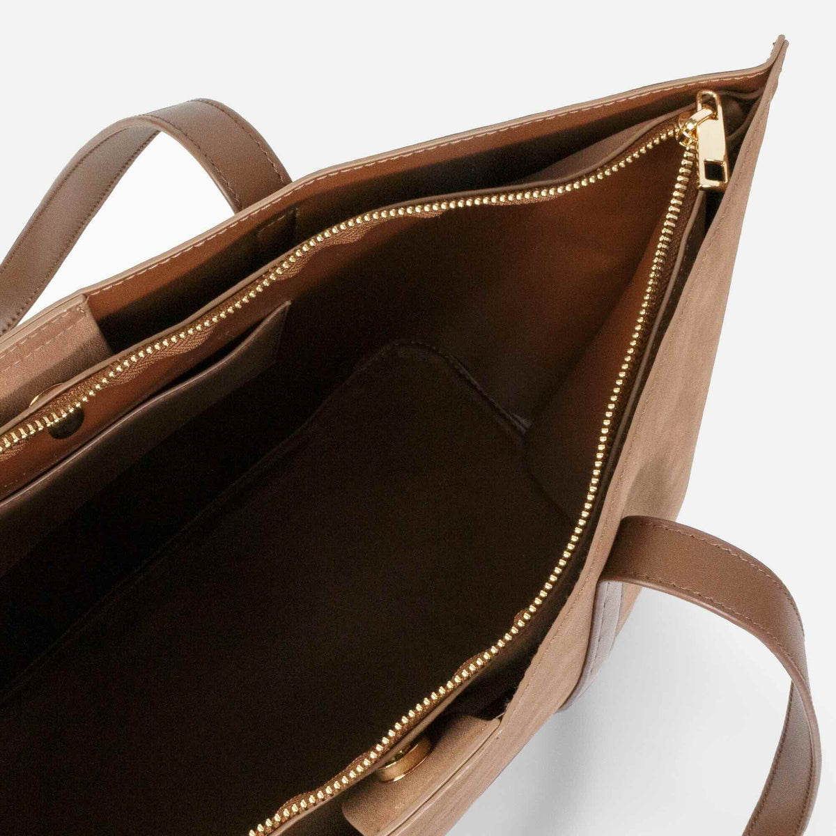 Pale brown suede-effect handbag with gold zipper, open interior showing organized compartments and two handles.