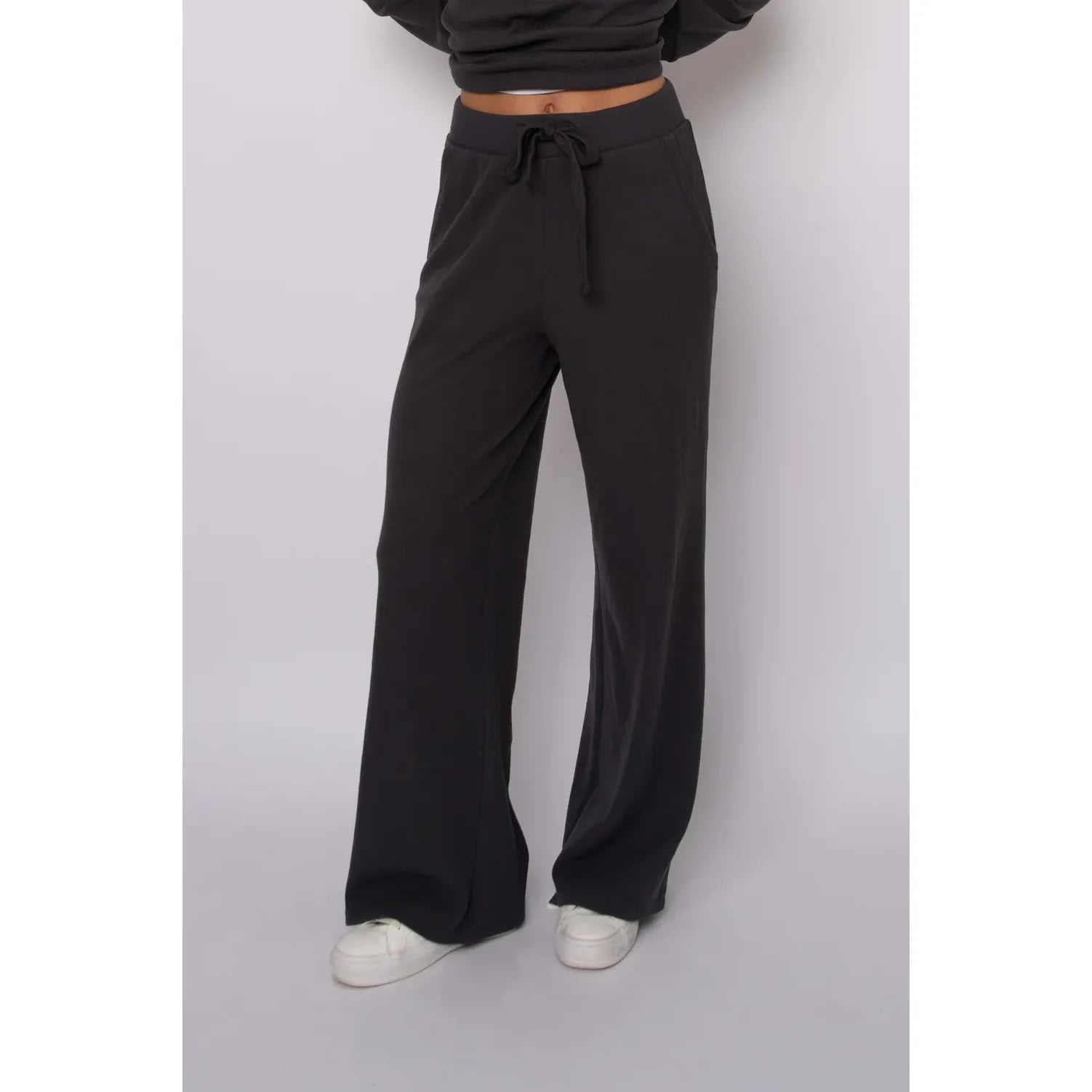 Black waffle-knit wide leg drawstring pants featuring a relaxed fit and cozy plush texture for effortless loungewear style.