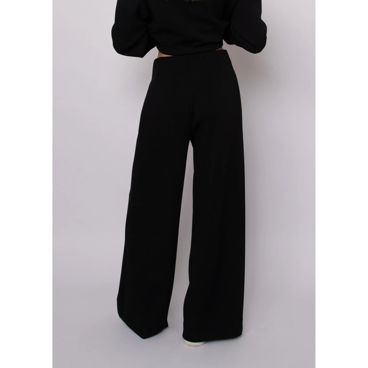 Black soft knit high-waisted wide-leg pull-on pants with self-tie waist and relaxed drape.