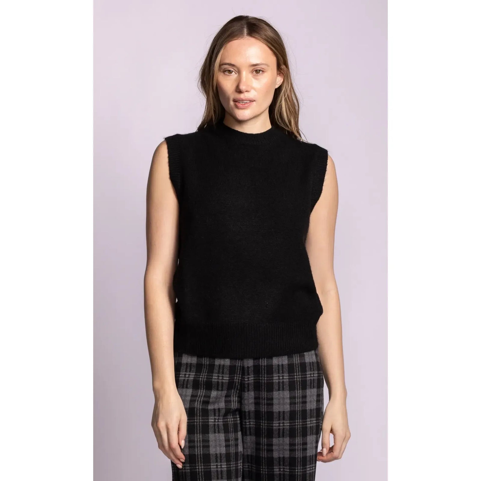 Black ribbed sleeveless sweater with structured shoulders and hem, designed as a versatile layering essential for a refined silhouette.