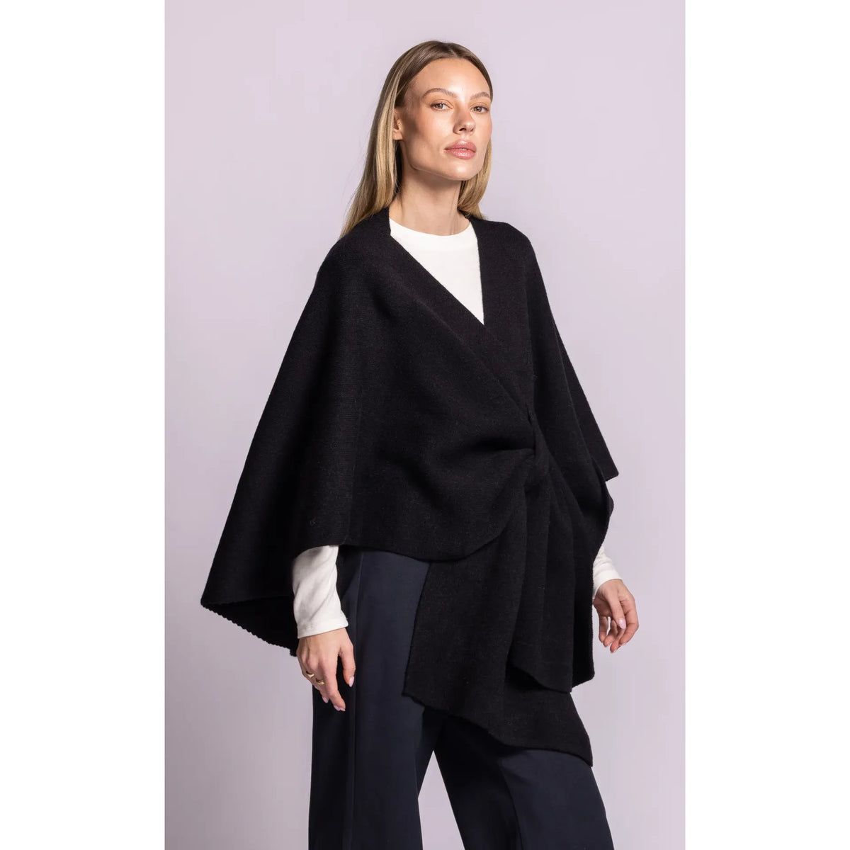 Black Lennon Wrap Sweater featuring a poncho silhouette, asymmetric hem, and adaptable waist tie for a sleek, layered look.
