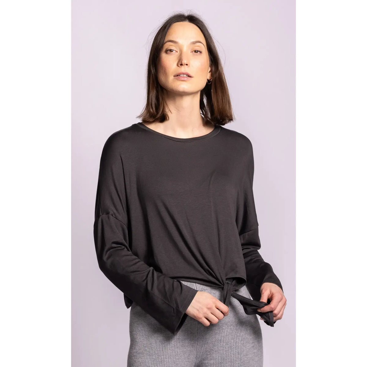 Model wearing a black Lenova top with dropped shoulders and a self-tie detail at the hem. Soft, lightweight drape for effortless style.