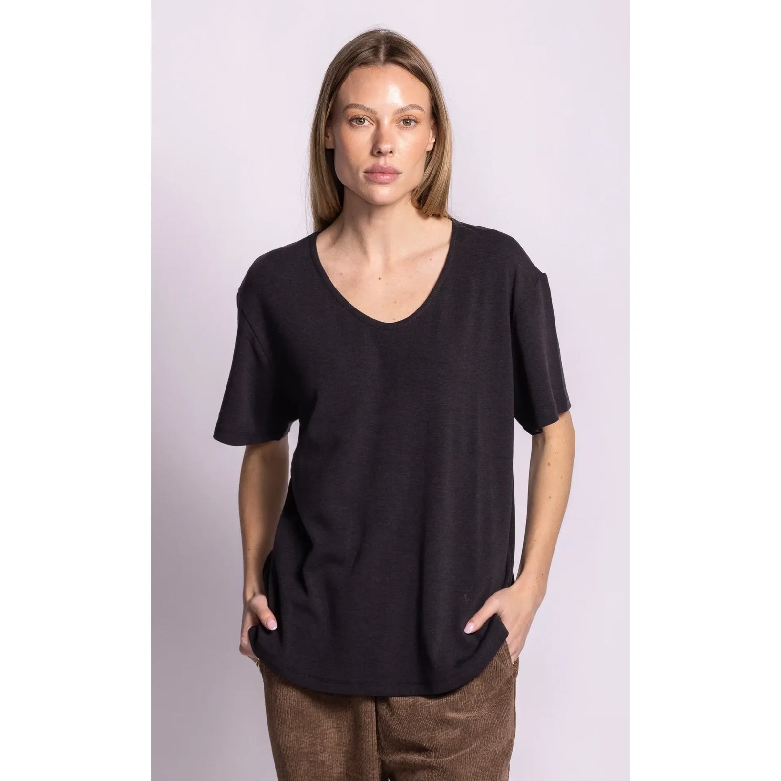 Model wearing a dark charcoal relaxed fit scoop neck top with dropped shoulders, featuring a cozy brushed lining for comfort.