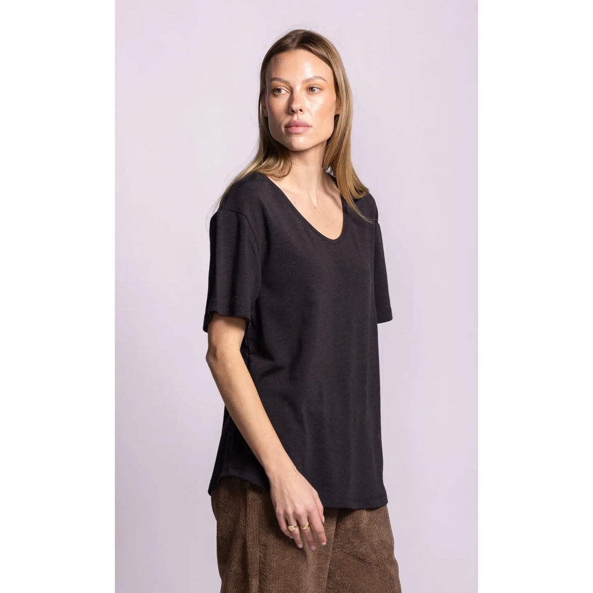 Model wearing a dark grey relaxed fit Rhiannon Top with a scoop neck and dropped shoulders.